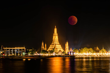 BANGKOK, THAILAND - November 8, 2022 : Lunar Eclipse, 
Super Red Full Moon taken from top side of “Wat Arun Temple”, 
This is a wonderful natural phenomenon with the view along Chao Praya River.