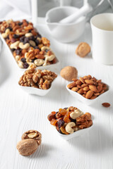 Mix of nuts and raisins on a white wooden table.
