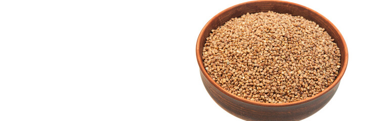 buckwheat in a clay bowl on a white background. the concept of a good harvest of buckwheat