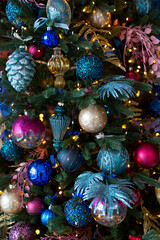 Close up of balls on Christmas tree. Bokeh garlands in the background. New Year and Christmas concept.