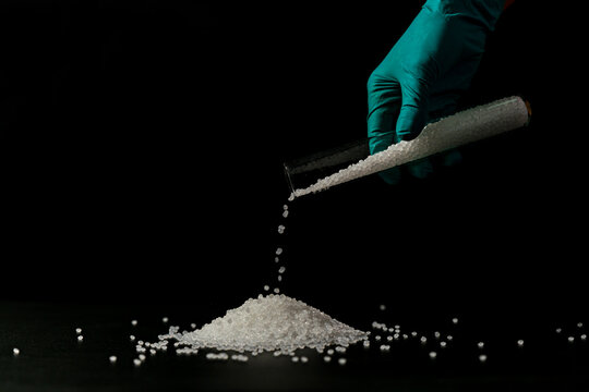 Close-up of plastic polymer granules. hand hold Polymer pellets. polymer plastic. compound polymer.	
