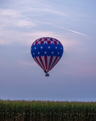 Vertical shot of a hot air balloon floating in the sky during sunrise