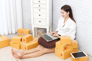 Asian women working with postal parcel, Seller prepare to send parcel to customer after checking order.Selling online ideas concept