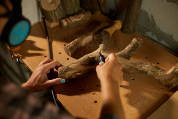 Female using power wood working tools graver, carving while crafting