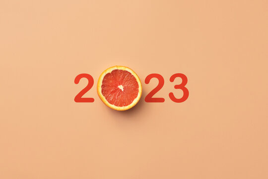 An unusual inscription 2023 with an orange. A symbol of the upcoming merry new year