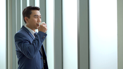 Smart and good looking Asian businessman relaxing and drinking a coffee.