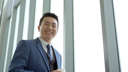 Smart and good looking Asian businessman relaxing and drinking a coffee.