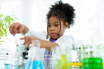 Lovely school girl excited to do a science experiment in science laboratory classroom. 