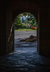 Arch of a building with a view of a garden