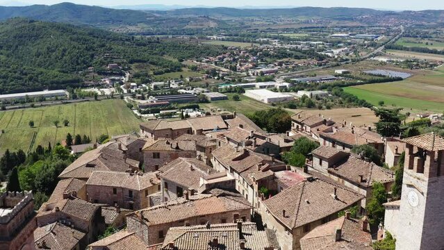 Aerial slow movement around buildings surrounded by trees in Italy