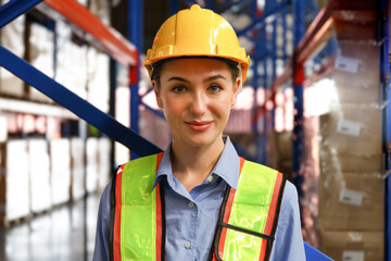 Smiling portrait of a young industrial engineer in a hard hat safety vest Workplace, warehouse, warehouse in logistics center