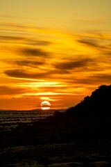 Breathtaking sunset sky over the desert field in Namibia, Africa, with a silhouette of a hill