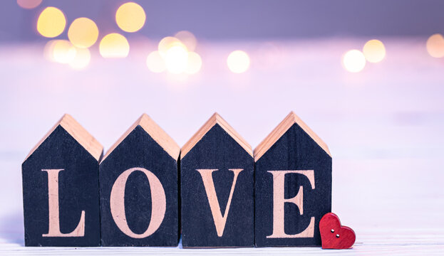 Decorative word love on a blurred background with bokeh lights. - Powered by Adobe