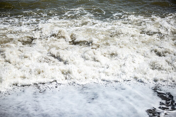 foamy coastal sea wave of a pebble beach