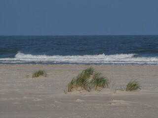 Beautiful sandy beach on Juist island in Germany with the North Sea in the background