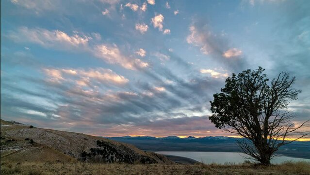 Colorful sunset timelapse from the top of West Mountain in Utah viewing Utah Lake in the distance.
