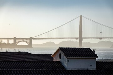 Silhouette of the Golden gate bridge of San Francisco behind a building