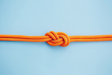Eight knot on a rope on a blue background. Copy space