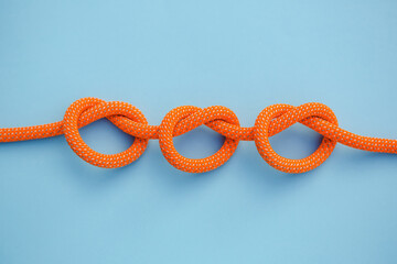 Three knots on a rope on a blue background