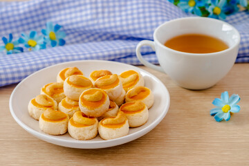 Cashew nut cookies or Singapore cookies on white plate and cup of tea.