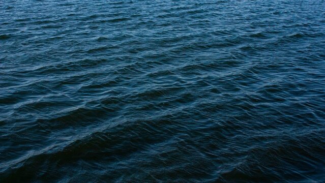 Aerial shot of abstract dark blue wavy sea water surface background