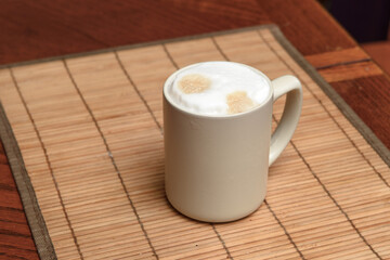 A cup of fresh coffee with cappuccino foam on the table