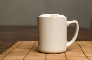 A cup of fresh coffee with cappuccino foam on the table