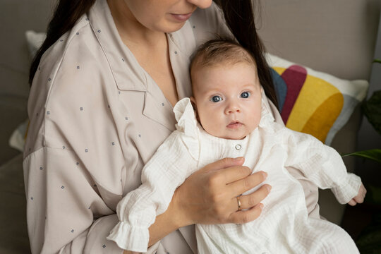 Anonimous young mom caressing infant