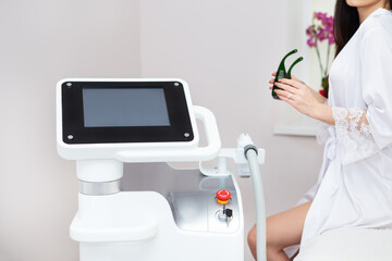 Professional laser hair removal machine, screen for setting up the hair removal process. Professional cosmetology, body epilation. Body care concept, client in the background.
