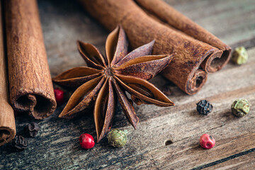 Composition with star anise and cinnamon sticks on a wooden background.