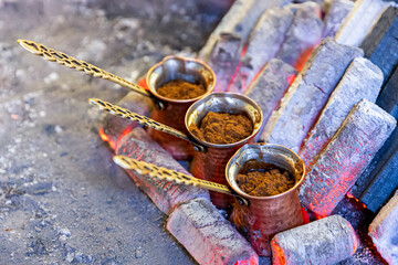 Turkish coffee cooked on embers. Street vendor cooks Turkish coffee on embers. Traditional pottery...