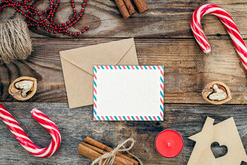 Blank paper, envelope and Christmas decor on wooden background, copy space.
