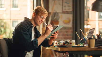 Focused Male Designer Drawing on Tablet Computer with Stylus Pen and Working with Inspiration in Modern Loft Space. Artist Creating Design for Shoes. Freelancer Doing Remote Work Concept.
