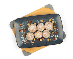 homemade coconut candies with almonds inside, sprinkled with coconut shavings, lying on a...