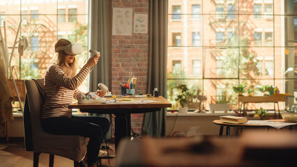 Woman Sitting Behind the Desk at Home or Creative Agency, Using Virtual Reality Headset and Controllers. Young Female Working from Living Room, Experiencing Futuristic Social Media Services.