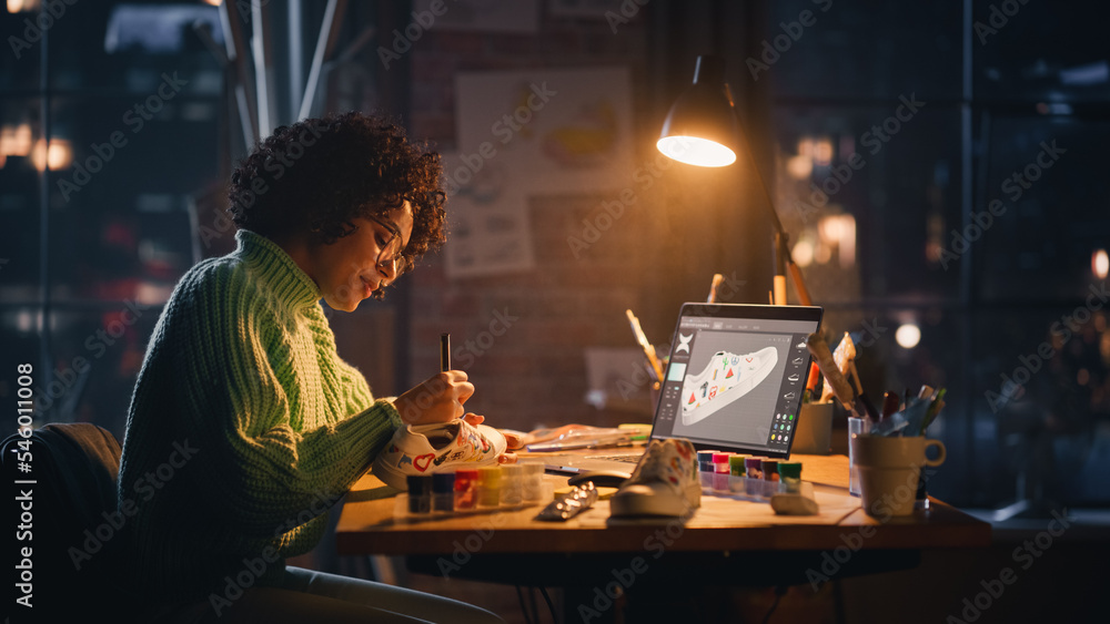 Fototapete Creating Trendy Design. Black Woman Feels Inspired While Drawing in the Evening. Female Designer Puts Patterns on Shoe Comparing with 3D Model on the Laptop Computer Screen.