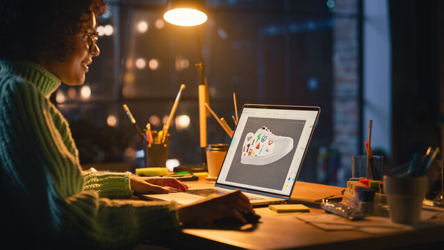 Latin Female Art Director Reviewing 3D Model of Shoe, Working on Laptop Computer at Loft Home Living Room. Artist Girl Making Visualisation in Special Software. Graphic Designer Concept.