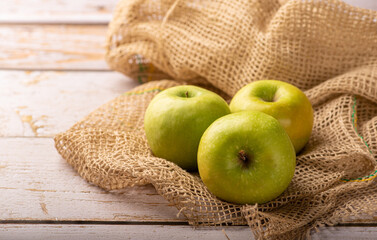 Green apple, green apples laid on rustic wood with rustic fabric, selective focus