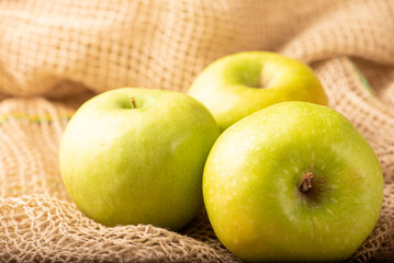 Green apple, green apples laid on rustic wood with rustic fabric, selective focus