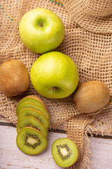 Green apple and kiwi, green apples and kiwi fruit laid on rustic wood with rustic fabric, selective focus
