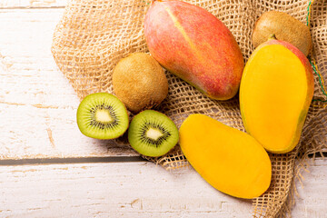 kiwi fruit and mango, kiwi fruit and mango placed on rustic wood with rustic fabric, selective focus
