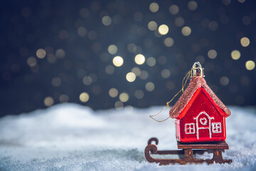 Christmas tree toy in the form of a red house on a sleigh in the snow. christmas, new year...