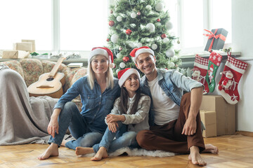 family having fun and playing together near Christmas tree indoors.