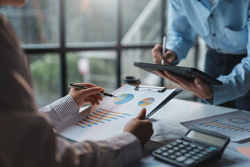 Close-up of businesspeople meeting to present at the meeting, new project plan, analysis, marketing strategy pointing to company graphs and charts for presentation.