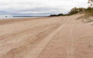 Sea view with green trees, a pier and sand