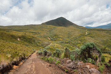 Naklejka na ściany i meble A dirt road against a mountain background at Chogoria Route, Mount Kenya