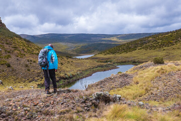 Rear view of a hiker at Lake Ellis, Chogoria Route in Mount Kenya National Park, Kenya