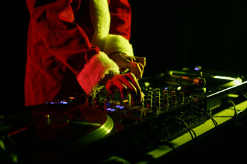 Santa Claus DJ mixing music set on New Year's Eve celebration in night club. Christmas party disc...