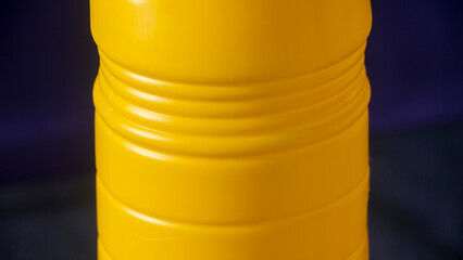 Botella de plástico amarillo con tapón azul de producto de limpieza