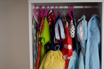 A background of Female childish wardrobe apparel hung comfortable vertical storage. Kids' girl...